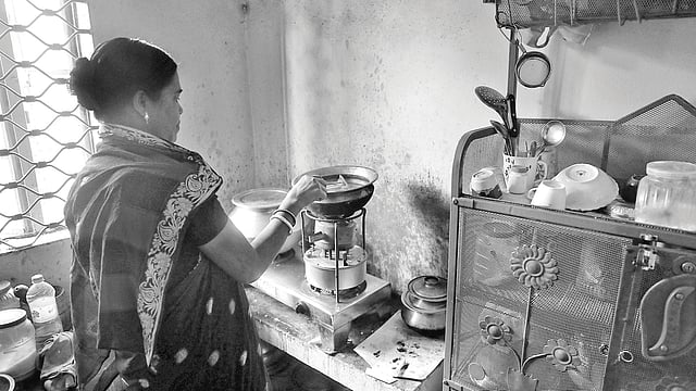 গ্যাস নেই। কেরোসিনের চুলায় চলছে রান্নার কাজ। গতকাল দুপুরে নগরের পাথরঘাটা এলাকায়।  ছবি: প্রথম আলো