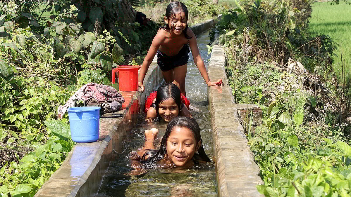 গভীর নলকূপ থেকে খেতে যাওয়া সেচের পানিতে দুরন্তপনায় মেতেছে তিন শিশু। শাজাহানপুর, বগুড়া, ২৫ ফেব্রুয়ারি। ছবি: সোয়েল রানা