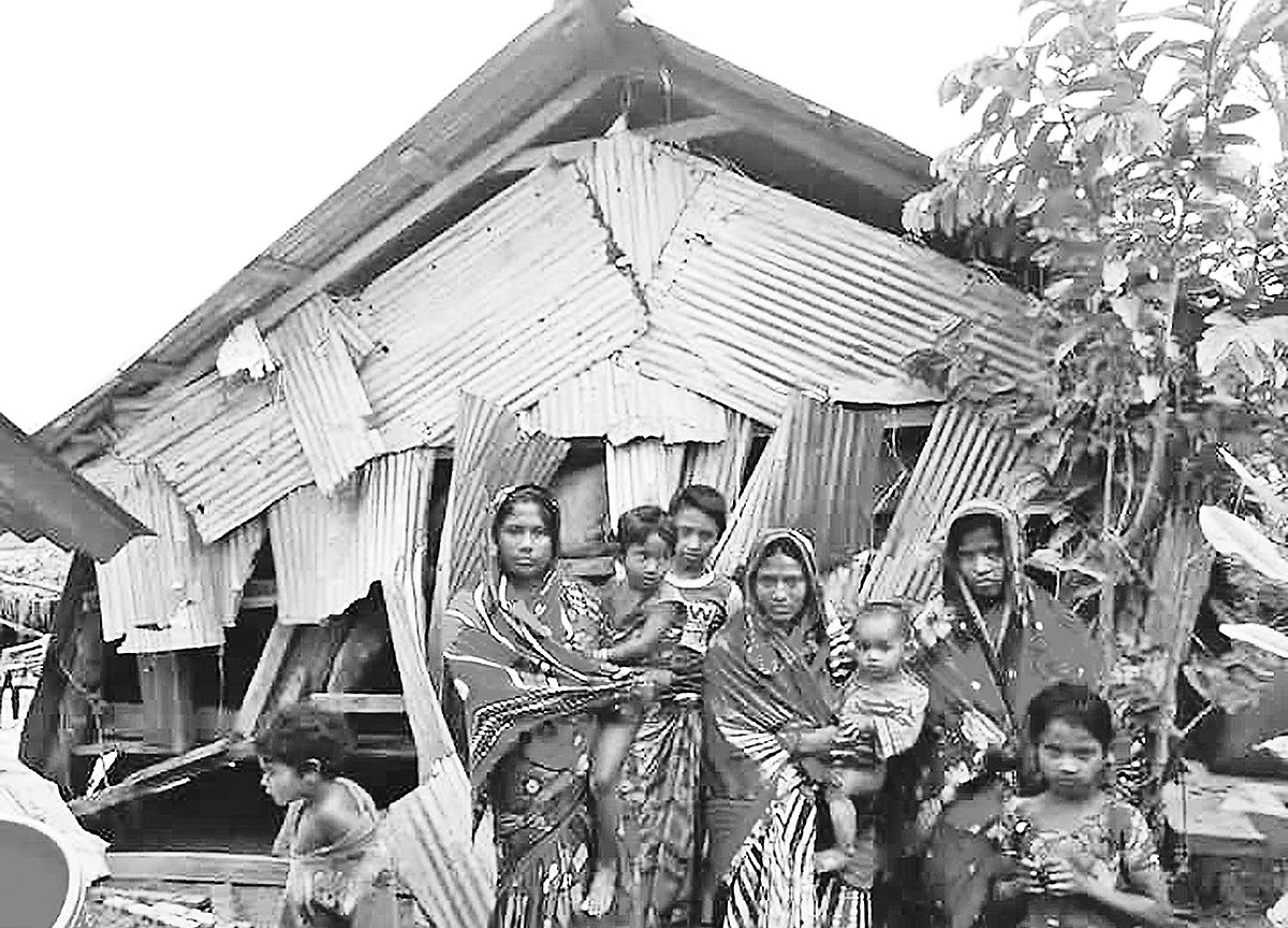 হাতিয়ার নিঝুম দ্বীপে ঝড়ে ক্ষতিগ্রস্ত বসতঘরের সামনে একটি পরিবারের সদস্যরা। গতকাল দুপুরে নিঝুম দ্বীপের ইসলামপুর এলাকায়।  প্রথম আলো