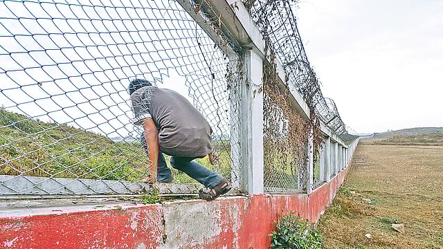 সিলেট এমএজি ওসমানী বিমানবন্দরের রানওয়ের কাছাকাছি নতুন সীমানাপ্রাচীর তৈরি করেছে কর্তৃপক্ষ। নতুন এই সীমানাপ্রাচীরের লোহার তার ভেঙে ভেতরে যাতায়াত করছে এলাকার লোকজন। গতকাল বিকেলে।  ছবি: আনিস মাহমুদ