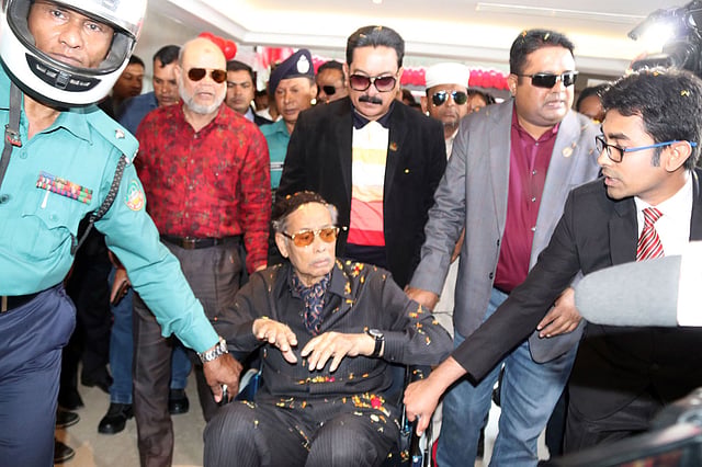 স্থানীয় একটি হোটেলে এরশাদকে হুইল চেয়ারে বসিয়ে নেওয়া হচ্ছে। ছবি: প্রথম আলো