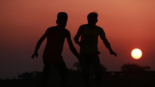 বসন্তের পড়ন্ত বিকেলে হাওরের মাঠে ফুটবল খেলায় মেতেছে একদল শিশু-কিশোর