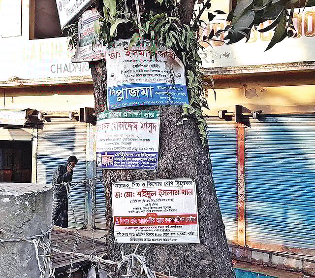 গাছে পেরেক দিয়ে সাঁটানো প্রচারপত্র। গতকাল মৌলভীবাজারের চাঁদনীঘাট এলাকায়।  প্রথম আলো