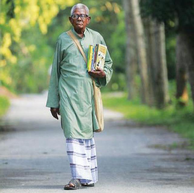 বই নিয়ে গ্রামের পথে পলান সরকার। প্রথম আলো ফাইল ছবি