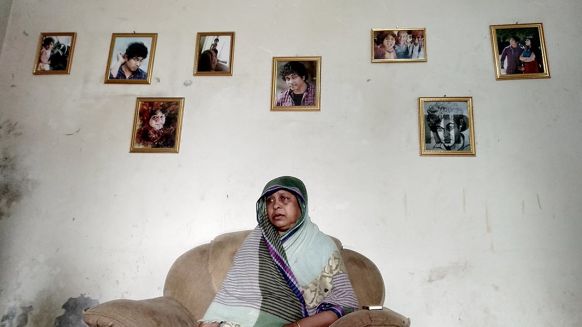 ইউএস–বাংলার উড়োজাহাজ দুর্ঘটনায় নিহত এফ এইচ প্রিয়কের ছবির মাঝে তাঁর মা ফিরুজা বেগম। ছবি: সাদেক মৃধা