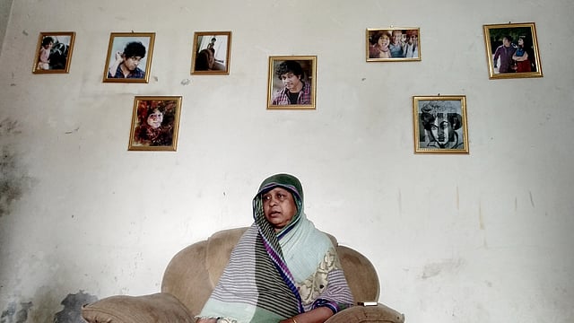 ইউএস–বাংলার উড়োজাহাজ দুর্ঘটনায় নিহত এফ এইচ প্রিয়কের ছবির মাঝে তাঁর মা ফিরুজা বেগম। ছবি: সাদেক মৃধা