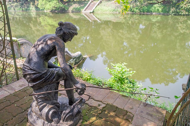 দিঘির শানবাঁধানো ঘাটে ধাতব ভাস্কর্য।