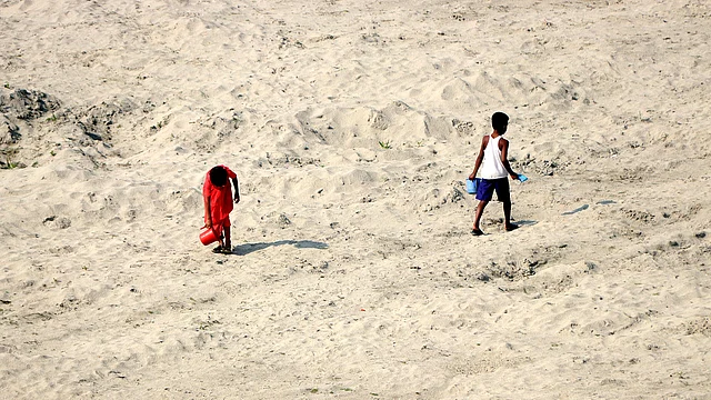 একটু পানি আছে এমন স্থানে গোসল করে বাড়ি ফিরছে দুই শিশু।