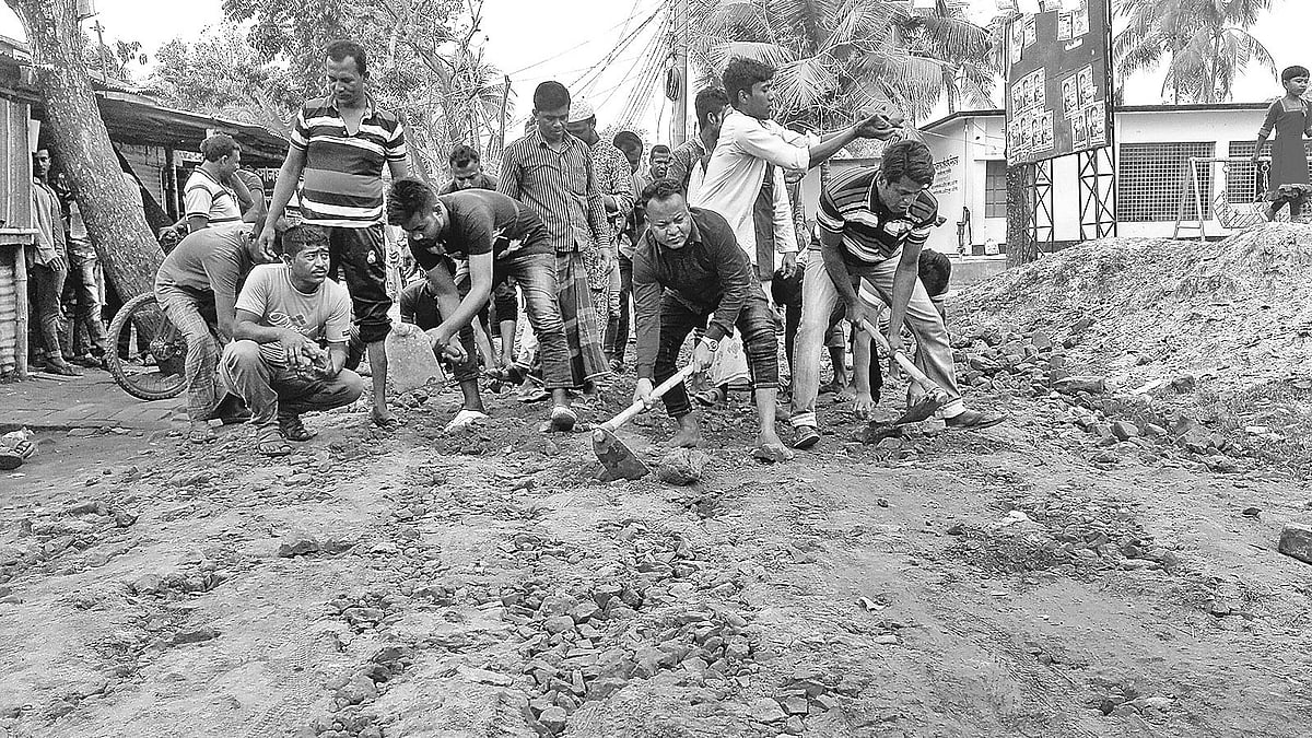 স্বেচ্ছাশ্রমে সড়কের সংস্কারকাজ চলছে। গতকাল সাতক্ষীরার মাছখোলা ক্লাব মোড়ে। প্রথম আলো