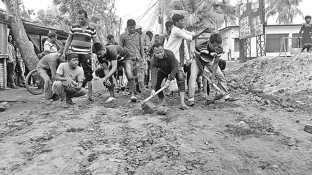 স্বেচ্ছাশ্রমে সড়কের সংস্কারকাজ চলছে। গতকাল সাতক্ষীরার মাছখোলা ক্লাব মোড়ে। প্রথম আলো
