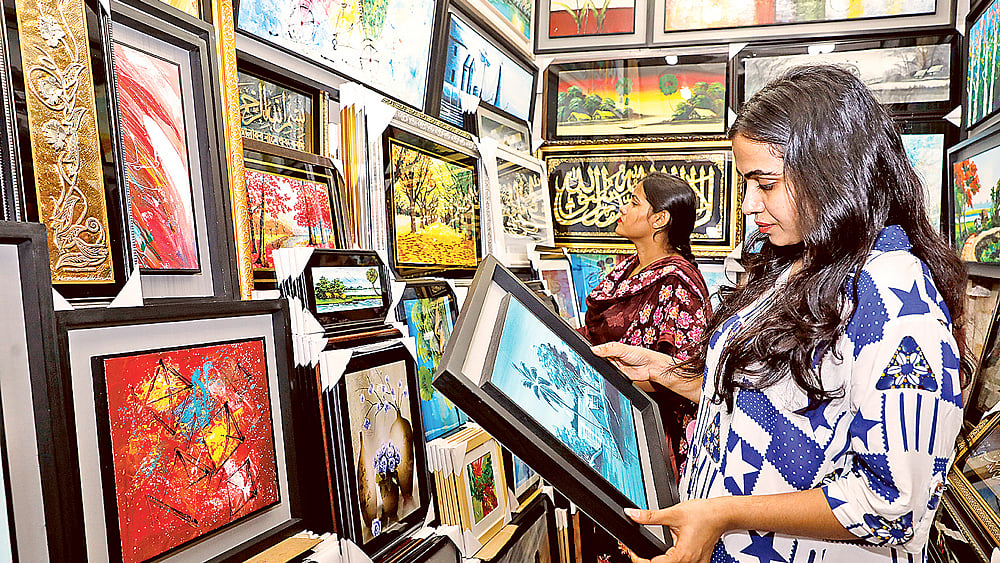 দোকানে ছবি পছন্দ করছেন ক্রেতারা। বুধবার রাজধানীর নিউ সুপার মার্কেটে । ছবি: আশরাফুল আলম