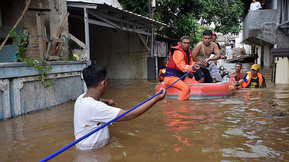 দক্ষিণ জাকার্তায় একটি পরিবারকে উদ্ধার করছেন উদ্ধারকর্মীরা। ছবি: রয়টার্স