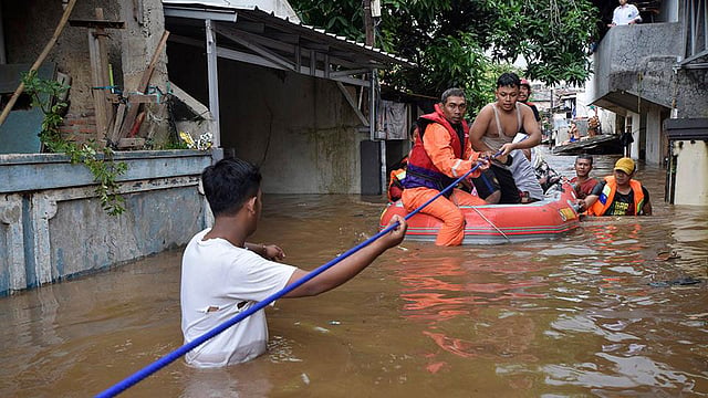 দক্ষিণ জাকার্তায় একটি পরিবারকে উদ্ধার করছেন উদ্ধারকর্মীরা। ছবি: রয়টার্স