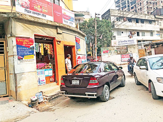 দুটি গাড়ি পাশাপাশি চললে হাঁটার জায়গা থাকে না এই সড়কে। সম্প্রতি জিগাতলার হাজারীবাগ থানা–সংলগ্ন এলাকায়।  ছবি: প্রথম আলো