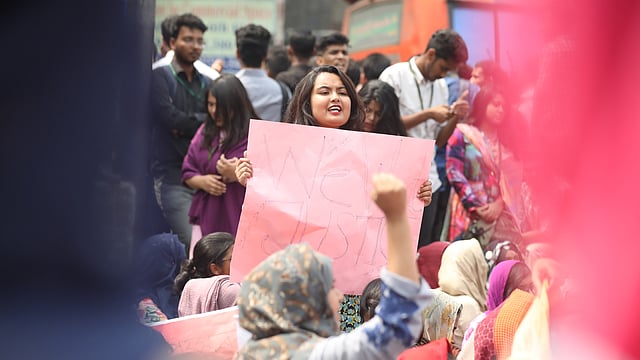 প্লাকার্ড হাতে এক শিক্ষার্থী।