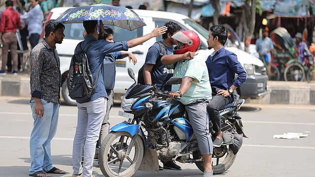 মোটরসাইকেলচালককে ঘটনাস্থল থেকে সরিয়ে দিচ্ছেন শিক্ষার্থীরা। ছবি: সাইফুল ইসলাম