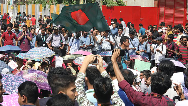 বাংলাদেশের জাতীয় পতাকা হাতে এক আন্দোলনকারী।