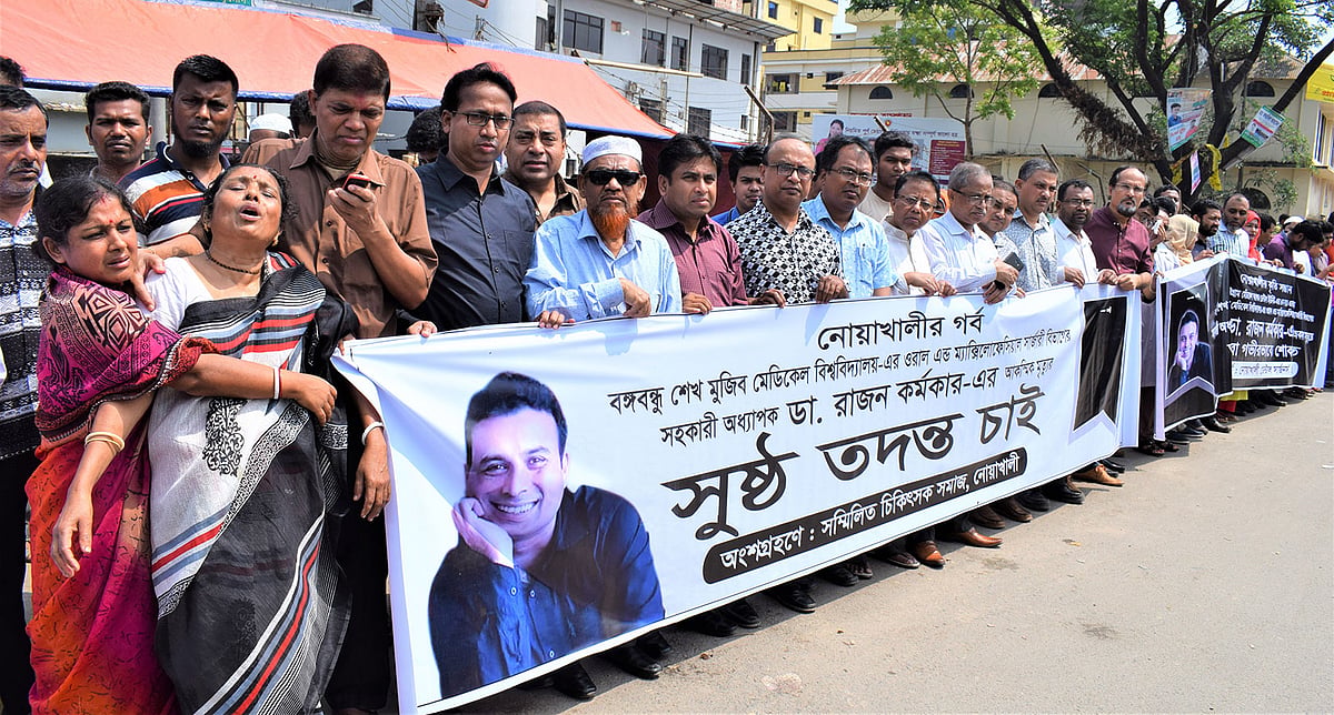 চিকিৎসক রাজন কর্মকারের মৃত্যুর ঘটনার সুষ্ঠু তদন্তের দাবিতে নোয়াখালী জেনারেল হাসপাতালের সামনের সড়কে চিকিৎসকেরা মানববন্ধন করেন। বৃহস্পতিবার, ২১ মার্চ, নোয়াখালী। ছবি: মাহবুবুর রহমান।