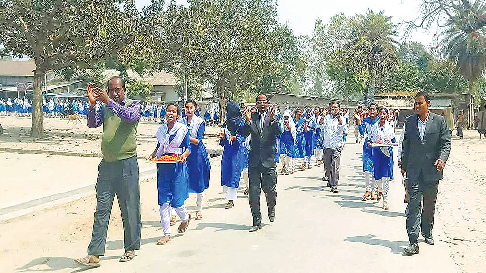 ঠাকুরগাঁওয়ের হরিপুর উপজেলার যাদুরাণী বালিকা উচ্চবিদ্যালয়ের শিক্ষক-শিক্ষার্থীরা ভাইস চেয়ারম্যানকে সংবর্ধনা দিতে শোভাযাত্রা নিয়ে আওয়ামী লীগের কার্যালয় যাচ্ছে।  ছবি: প্রথম আলো
