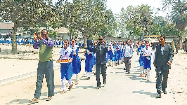ঠাকুরগাঁওয়ের হরিপুর উপজেলার যাদুরাণী বালিকা উচ্চবিদ্যালয়ের শিক্ষক-শিক্ষার্থীরা ভাইস চেয়ারম্যানকে সংবর্ধনা দিতে শোভাযাত্রা নিয়ে আওয়ামী লীগের কার্যালয় যাচ্ছে।  ছবি: প্রথম আলো
