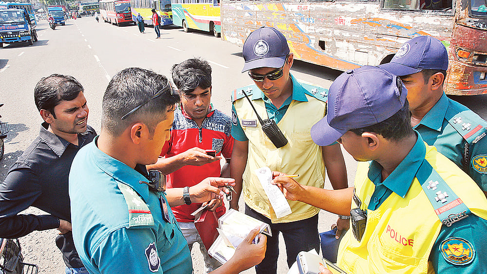 সড়কে শৃঙ্খলা ফেরাতে সকাল থেকে ট্রাফিক পুলিশের অভিযান। বেলা দুইটা পর্যন্ত ১৬টি বাসের বিরুদ্ধে নানা অনিয়মের জন্য মোট ৩১টি মামলা করা হয়েছে। গতকাল দুপুরে রাজধানীর মানিক মিয়া অ্যাভিনিউয়ে। ছবি: জাহিদুল করিম