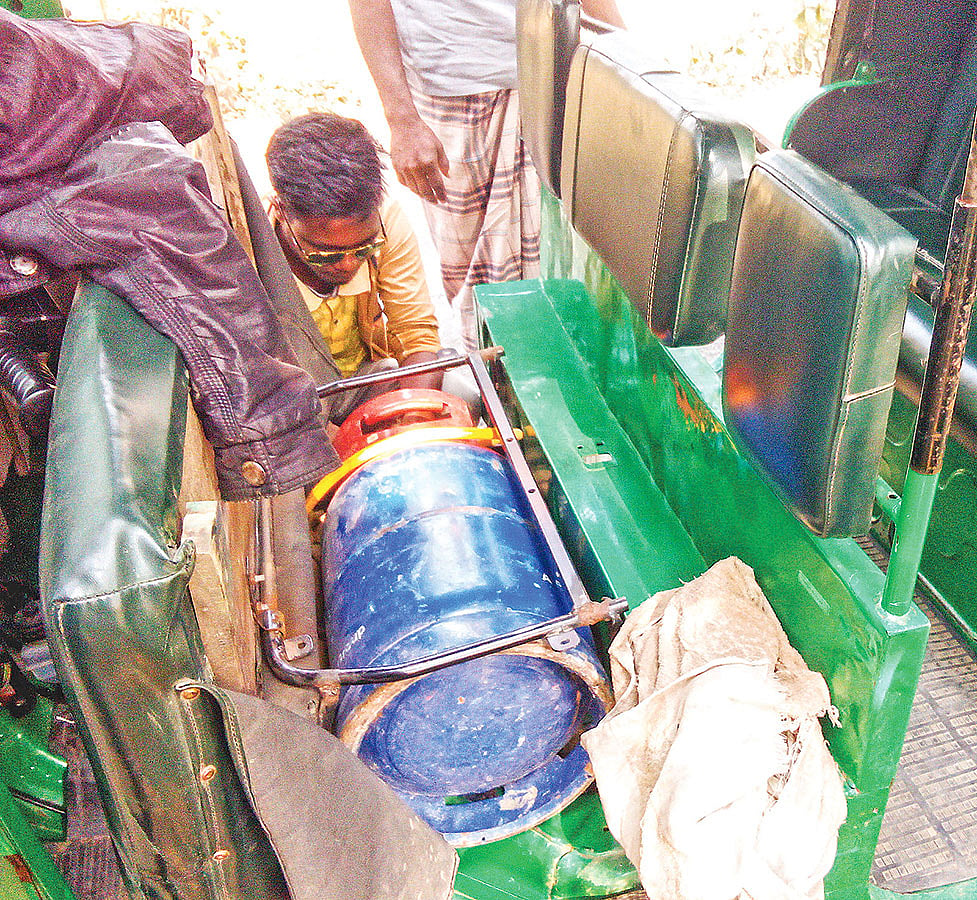 অটোরিকশায় এলপি গ্যাসের সিলিন্ডার স্থাপন করছেন একজন কারিগর। সম্প্রতি নওগাঁর রানীনগর উপজেলা শহরের বিএনপির মোড় এলাকায়।  ছবি: প্রথম আলো