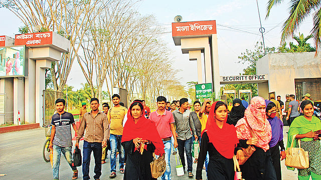 এক দশকে মোংলা ইপিজেডে বিনিয়োগ বৃদ্ধির পাশাপাশি বেড়েছে রপ্তানি ও কর্মসংস্থান। তবে এখনো প্লট বরাদ্দ পাওয়া সব প্রতিষ্ঠান উৎপাদনে আসেনি। কাজ শেষে ইপিজেড থেকে বেরিয়ে আসছেন শ্রমিকেরা। সম্প্রতি মোংলা ইপিজেডের প্রধান ফটক এলাকায়।  ছবি: প্রথম আলো