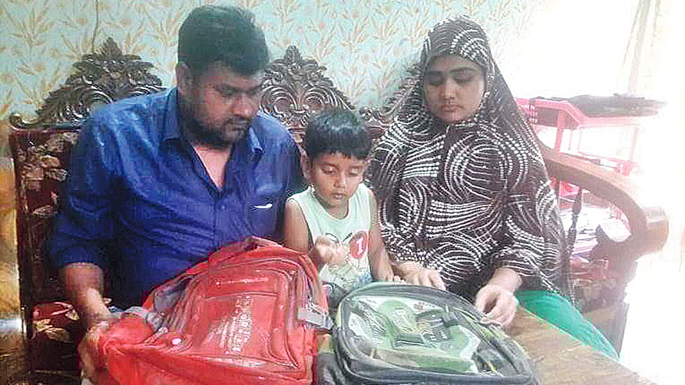সড়ক দুর্ঘটনায় নিহত দুই সন্তানের ব্যাগ নিয়ে স্মৃতি হাতড়ে বেড়াচ্ছেন বাবা–মা। গতকাল কেরানীগঞ্জে।