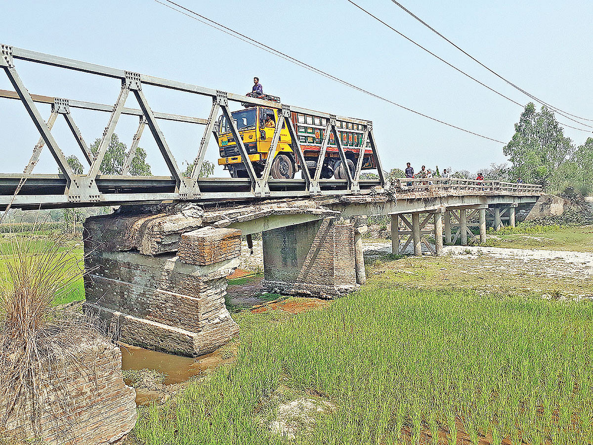নীলফামারীর ডোমার উপজেলার বখেড়ুয়া নদীর ওপর নির্মিত ঝুঁকিপূর্ণ সেতু দিয়ে চলাচল করছে যানবাহন। গত বৃহস্পতিবার দুপুরে তোলা ছবি। প্রথম আলো
