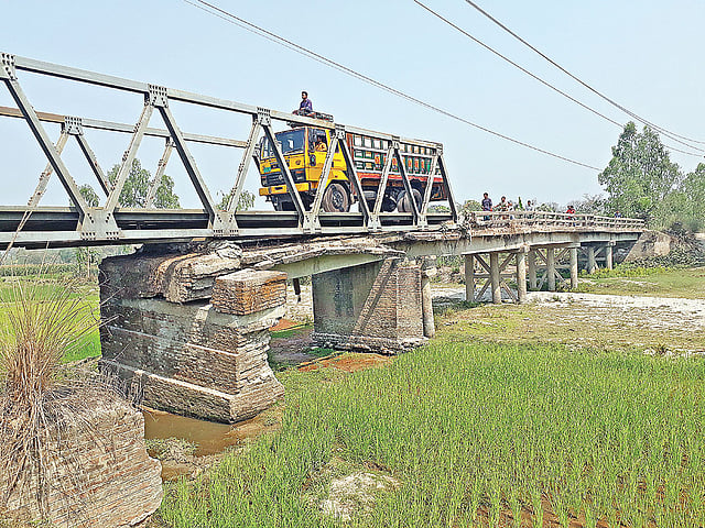 নীলফামারীর ডোমার উপজেলার বখেড়ুয়া নদীর ওপর নির্মিত ঝুঁকিপূর্ণ সেতু দিয়ে চলাচল করছে যানবাহন। গত বৃহস্পতিবার দুপুরে তোলা ছবি।  প্রথম আলো