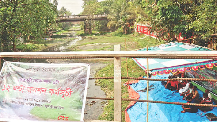 ইছামতী নদী রক্ষার দাবিতে অনশন কর্মসূচি পালন করছেন ‘আমাদের ইছামতী’ নামের একটি সংগঠনের সদস্যরা। গতকাল পাবনা শহরের ইছামতীর খেয়াঘাট এলাকায়।  ছবি: প্রথম আলো