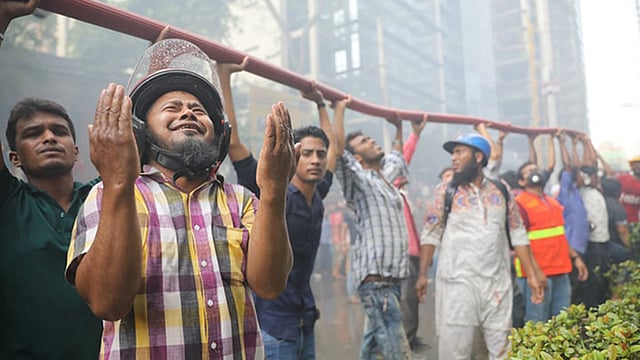 চলছে উদ্ধার কাজ। এরই মধ্যে এক ব্যক্তি হাত তুলে স্রষ্টার কাছে বিপদ থেকে রক্ষার প্রার্থনা করছেন। বনানী, ঢাকা, ২৮ মার্চ। ছবি: আবদুস সালাম