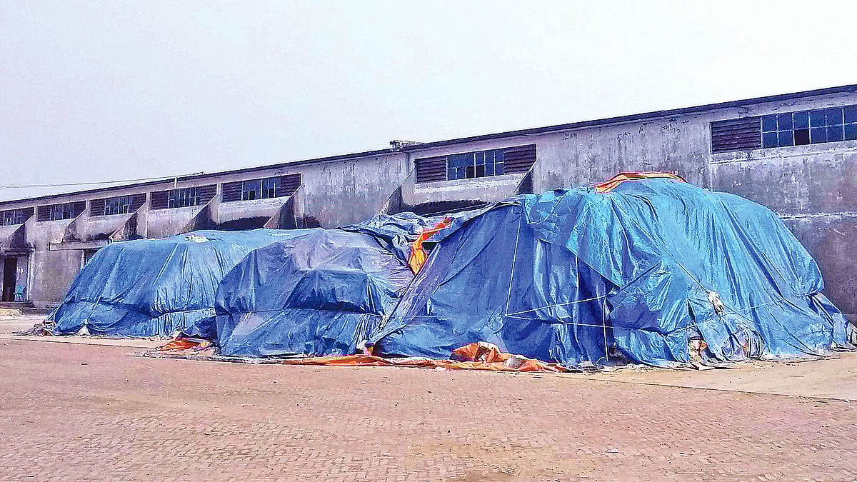 বগুড়া শহরের তিন মাথা এলাকায় বাফার গুদামের আঙিনায় কয়েক বছর ধরে রাখা সারের স্তূপ। গতকাল দুপুরে।  প্রথম আলো