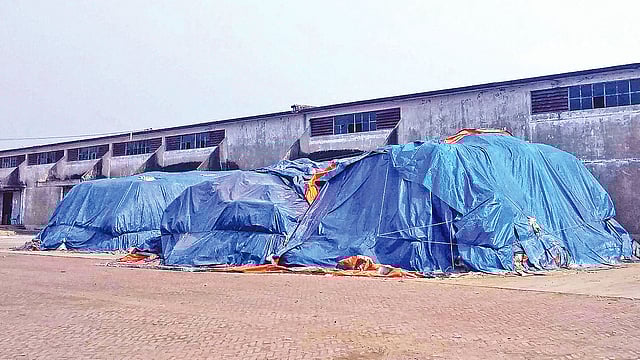 বগুড়া শহরের তিন মাথা এলাকায় বাফার গুদামের আঙিনায় কয়েক বছর ধরে রাখা সারের স্তূপ। গতকাল দুপুরে।  প্রথম আলো