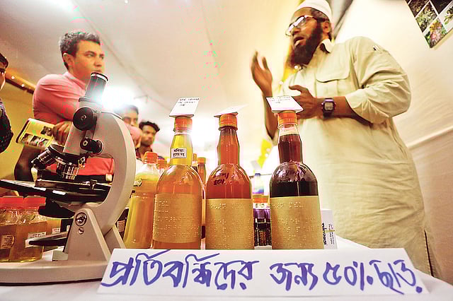 বিসিকের মেলায়  মধু চেনার উপায় উপস্থাপন করছেন সৈয়দ মুহাম্মদ মঈনুল আনোয়ার। গত মঙ্গলবার বিকেলে।  প্রথম আলো