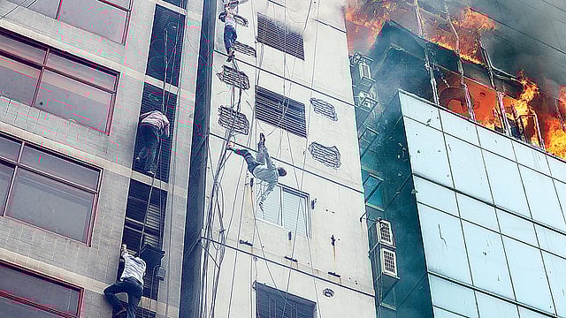 রাজধানীর বনানীর বহুতল ভবন এফ আর টাওয়ারে ভয়াবহ অগ্নিকাণ্ডের ঘটনায় জীবন বাঁচাতে ঝুঁকি নিয়ে তার বেয়ে ওপর থেকে নিচে নামতে থাকেন কয়েকজন। এ সময় এক ব্যক্তি হাত ফসকে পড়ে যান। গতকাল বেলা দুইটায়।  ছবি: সাজিদ হোসেন