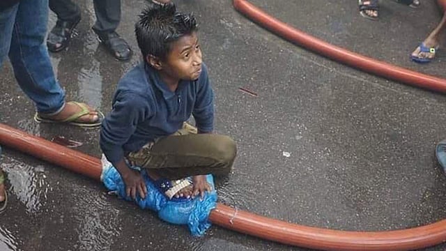 ফাটা পাইপ থেকে পানি যাতে ছড়িয়ে পড়ে নষ্ট না হয়  সে জন্য চেষ্টা করে যাচ্ছে নাইম। গতকাল নাইমের এ ছবিটি সামাজিক যোগাযোগমাধ্যমে ভাইরাল হয়। ছবি: সংগৃহীত