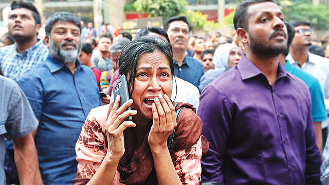 ভবনে আটকে পড়া স্বামীর খোঁজে ঘটনাস্থলে কান্নায় ভেঙে পড়েন এই নারী।  প্রথম আলো
