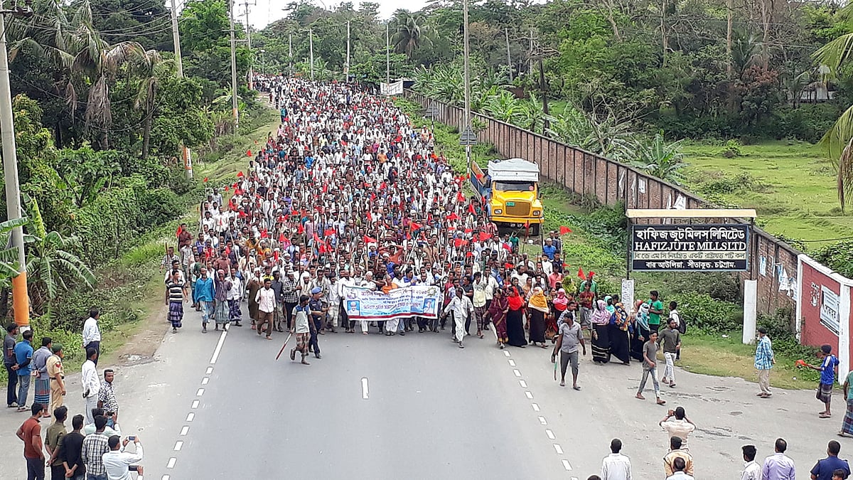 মজুরি কমিশন বাস্তবায়নসহ ১১ দফা দাবিতে চট্টগ্রামের সীতাকুণ্ডে রাষ্ট্রায়ত্ত পাটকল কারখানা হাফিজ জুট মিলসের শ্রমিকেরা লাঠি-লাল পতাকা নিয়ে বিক্ষোভ মিছিল করেছেন। ছবি: প্রথম আলো