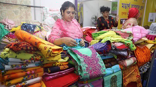 নানা নকশার থ্রিপিস নিয়ে মেলায় এক নারী উদ্যোক্তা।