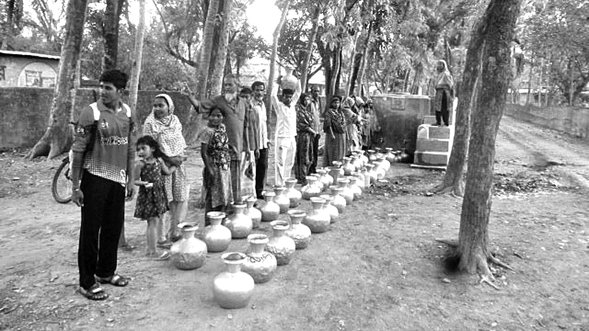 সুপেয় পানি সংগ্রহের জন্য লাইনে দাঁড়িয়েছেন স্থানীয় বাসিন্দারা। সাতক্ষীরা সদর উপজেলার দেবালয় গ্রামে।  ছবি: প্রথম আলো