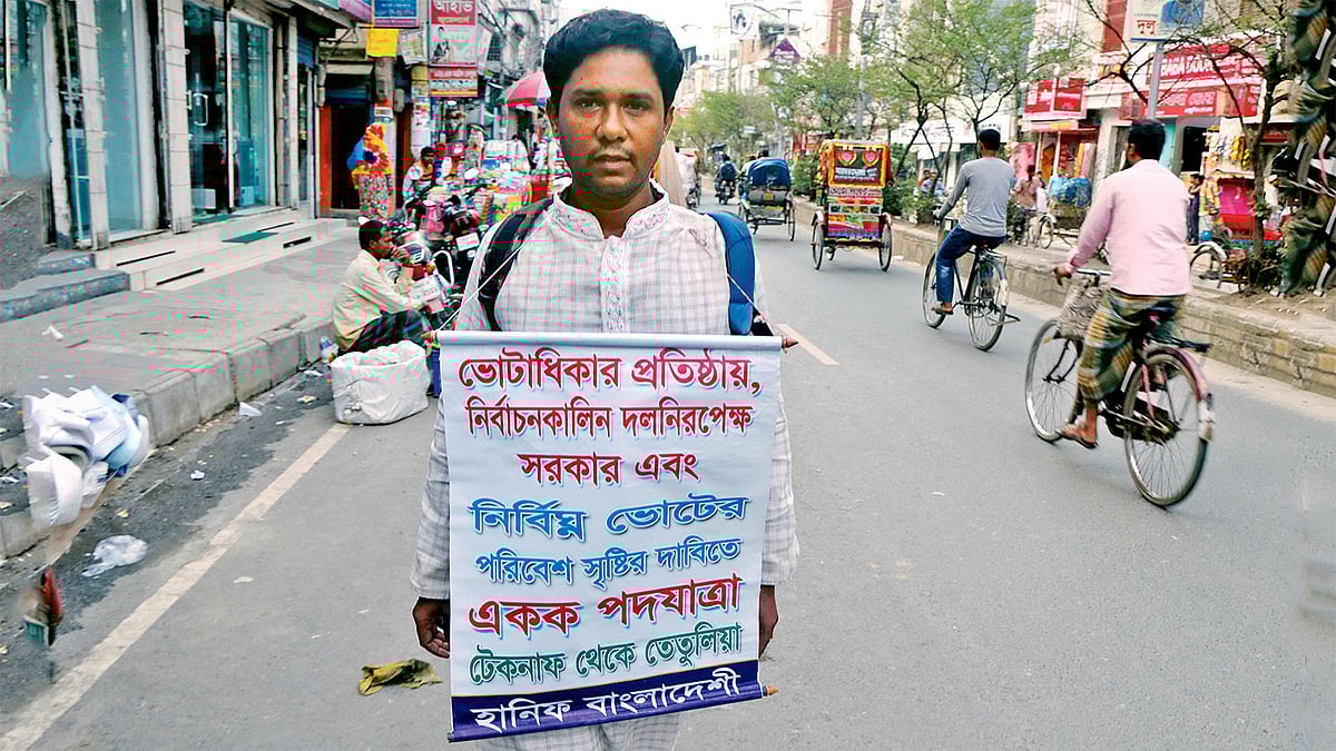 একক পদযাত্রায় মোহাম্মদ হানিফ। গতকাল বগুড়া শহরের সাতমাথা-মাটিডালি সড়কের ঝাউতলা এলাকায়।  ছবি: প্রথম আলো