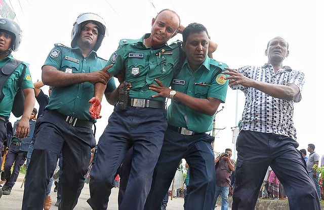 সংঘর্ষ চলাকালে আহত এক পুলিশ সদস্য। ছবি: সাদ্দাম হোসেন