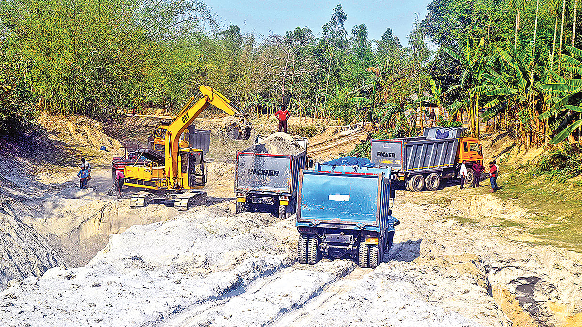 রংপুরের তারাগঞ্জের বুড়িরহাট-ঘোনপাড়া রাস্তার পাশ থেকে বালু তুলে ট্রলিতে ভরা হচ্ছে।  প্রথম আলো