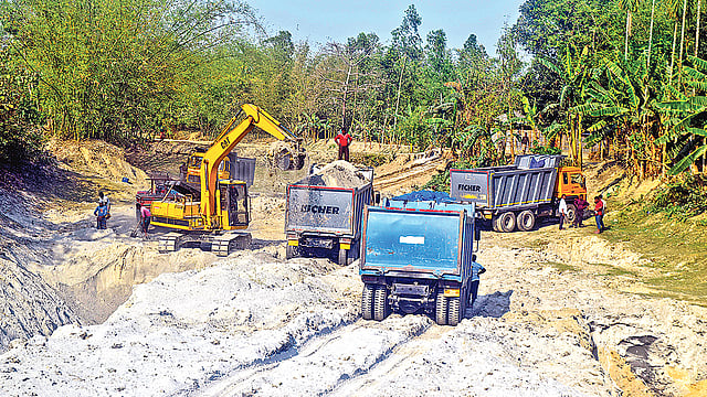 রংপুরের তারাগঞ্জের বুড়িরহাট-ঘোনপাড়া রাস্তার পাশ থেকে বালু তুলে ট্রলিতে ভরা হচ্ছে।  প্রথম আলো