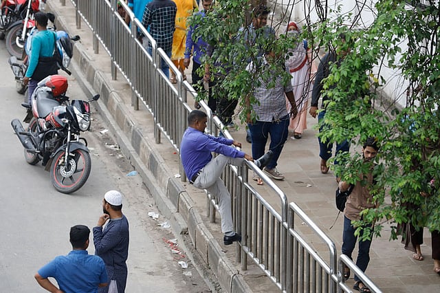 মাঝরাস্তা দিয়ে পার হতে না পেরে এক পথচারী বাধ্য হয়ে পথচারী–সেতুতে যাওয়ার এই চেষ্টা।