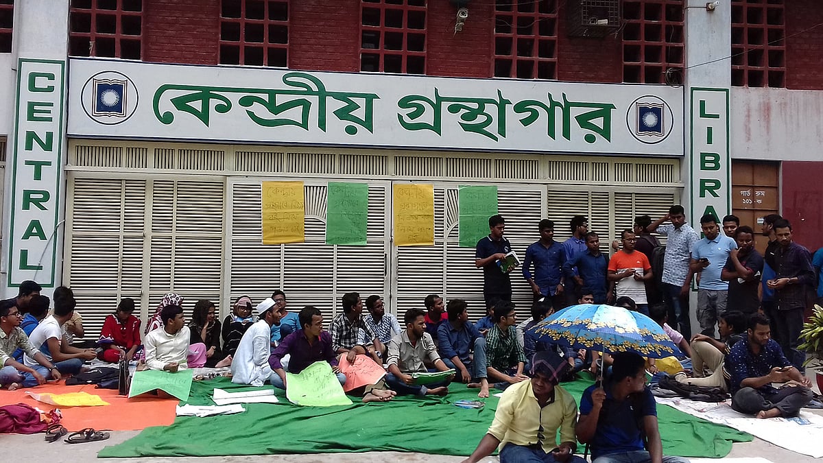 রাজশাহী বিশ্ববিদ্যালয়ের কেন্দ্রীয় গ্রন্থাগারে বই নিয়ে প্রবেশের দাবিতে গ্রন্থাগারের সামনে অবস্থান নেন শিক্ষার্থীরা। আজ রোববার বেলা সাড়ে ১২টার দিকে গ্রন্থাগারের সামনে। ছবি: তাপস কুমার সরকার