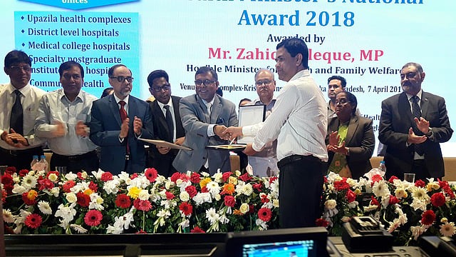 স্বাস্থ্যমন্ত্রী জাহিদ মালেকের কাছ থেকে জাতীয় পুরস্কার গ্রহণ করেন উপজেলা স্বাস্থ্য ও পরিবার পরিকল্পনা কর্মকর্তা শেখ আবু শাহীন। ছবি: সংগৃহীত