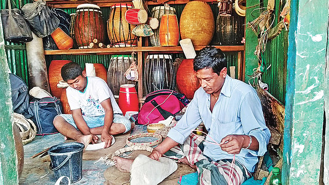 ঢোল তৈরিতে ব্যস্ত পিতা–পুত্র। গত বৃহস্পতিবার গাজীপুর সদরের দরগারচালা এলাকায়।