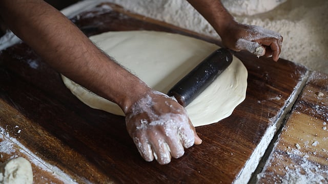 বাখরখানির জন্য তৈরি খামির বেলছেন এক শ্রমিক।
